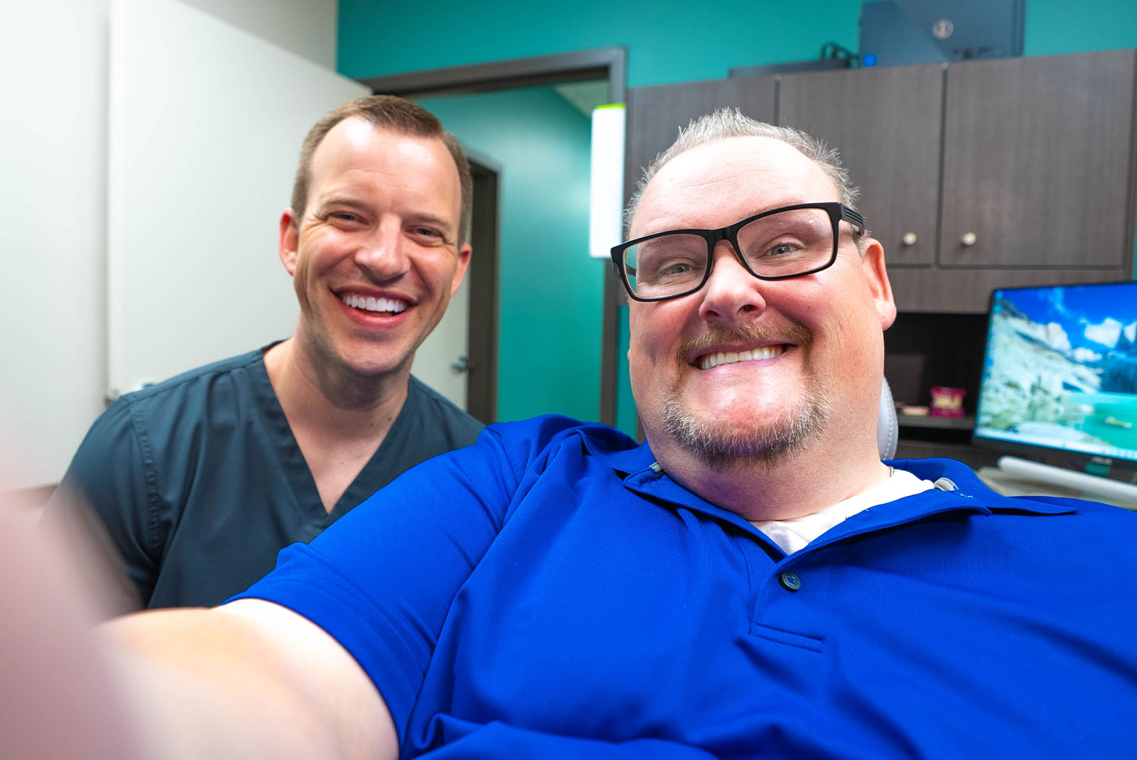 patient and doctor both smiling brightly after dental procedure