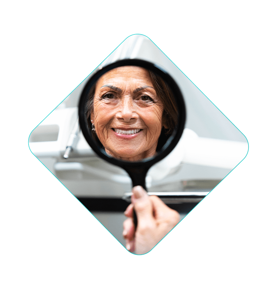 patient smiling within a handheld mirror