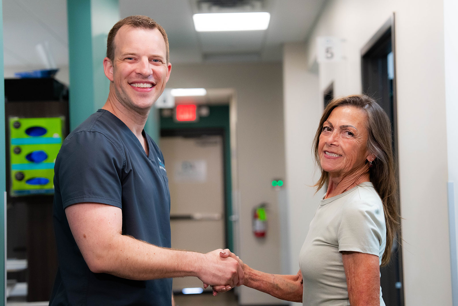 doctor and patient shaking hands with smiling after patient's procedure