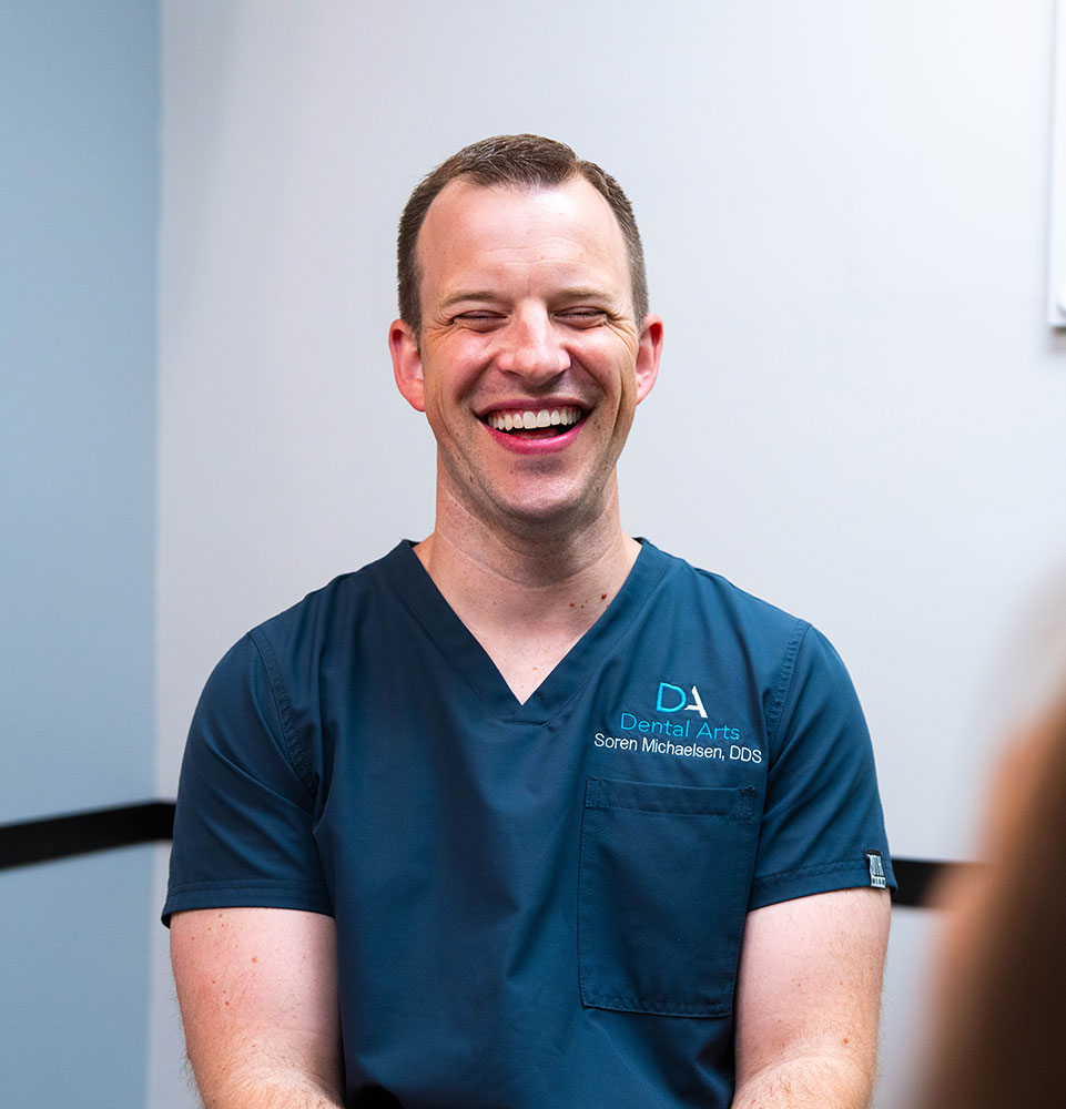 doctor laughing and smiling brightly while with patient for their dental procedure