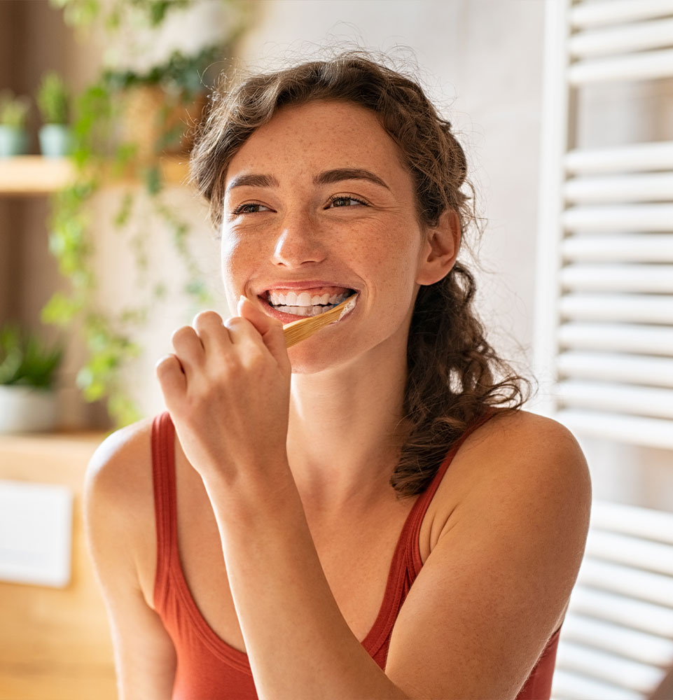 person smiling and brushing their teeth