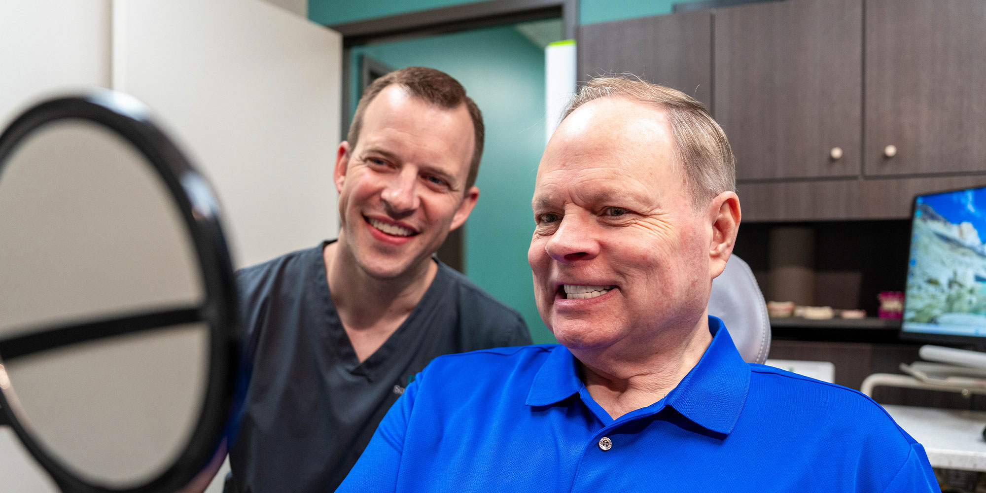 patient smiling brightly with doctor after patient's dental procedure