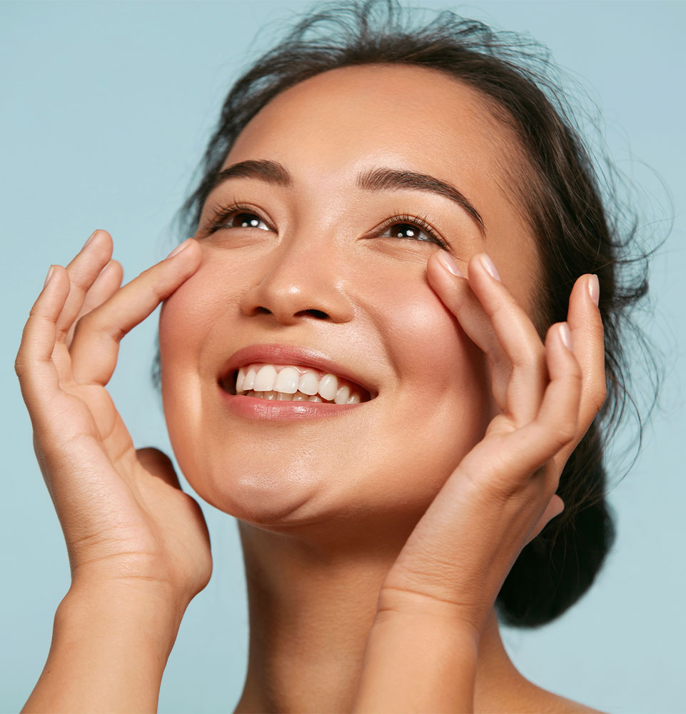 young model smiling brightly with glowing radiant skin