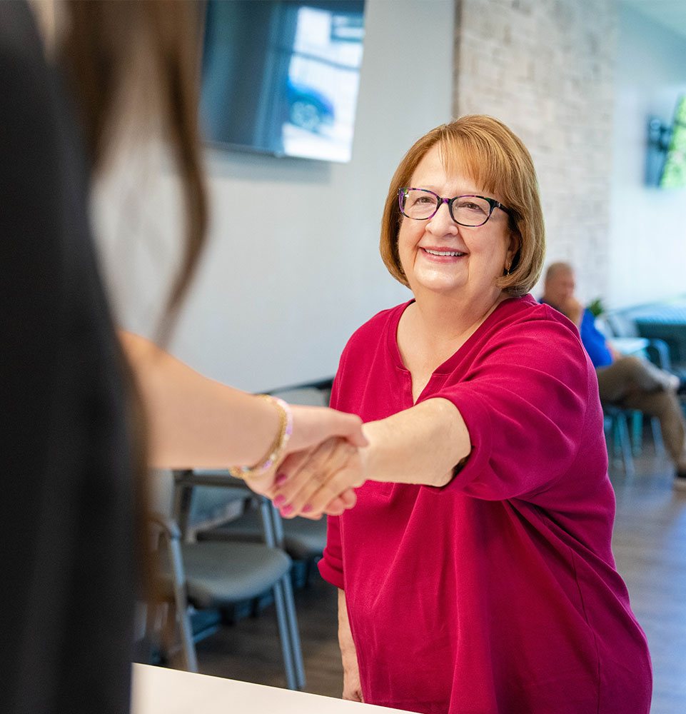 patient being helped at the front desk by staff members within the dental center