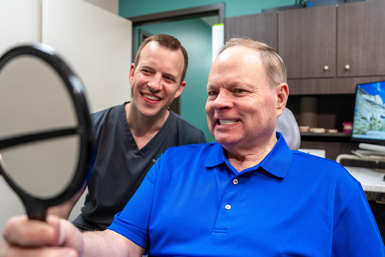 patient smiling brightly with doctor after dental procedure
