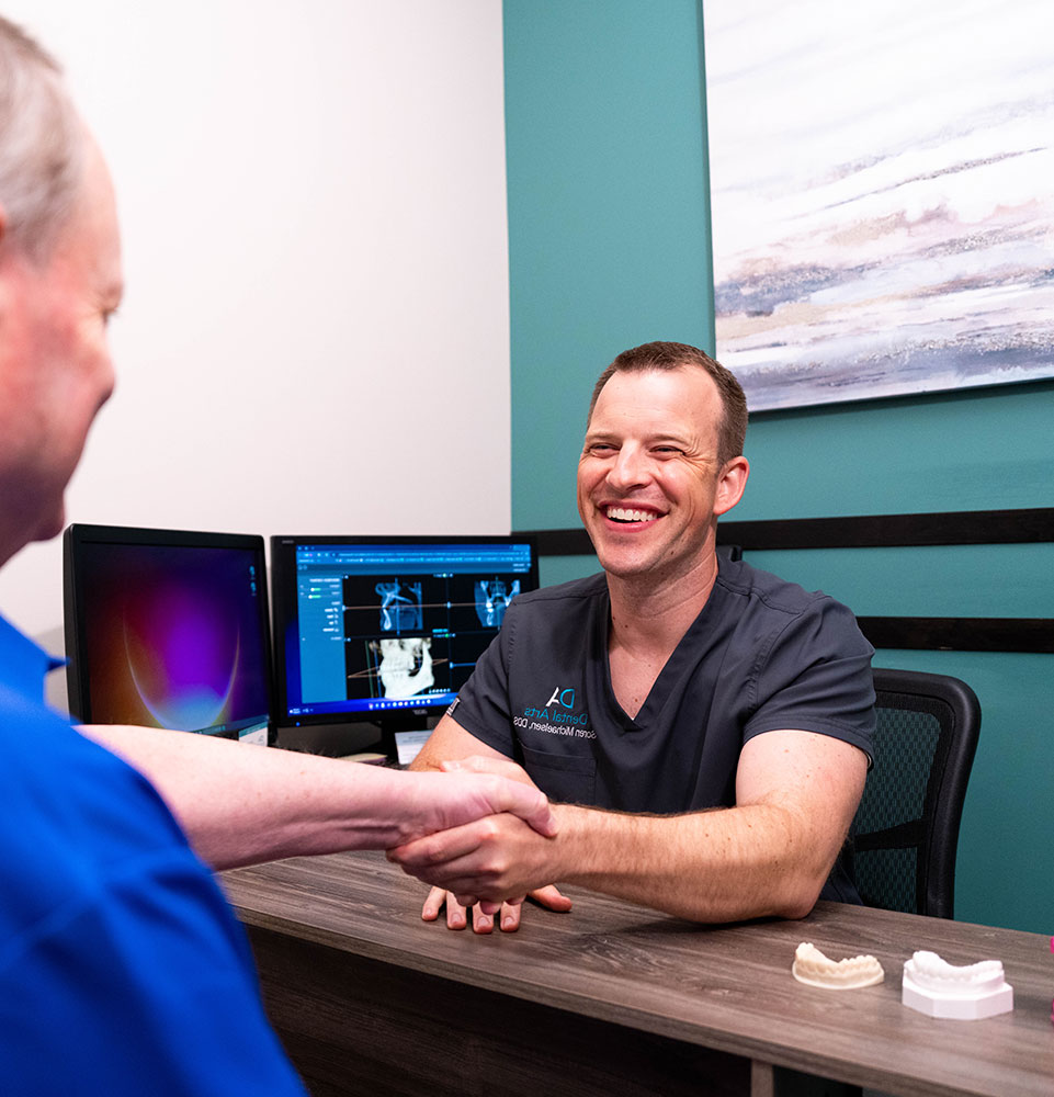 doctor shaking hands with patient during their dental consultation