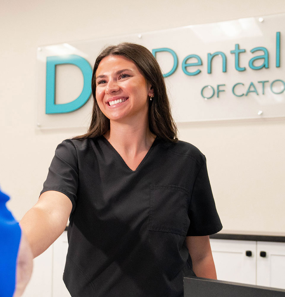 staff member shaking hands with greeting dental patient within the dental center