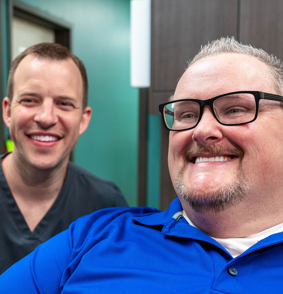patient and doctor smiling brightly after patient dental procedure