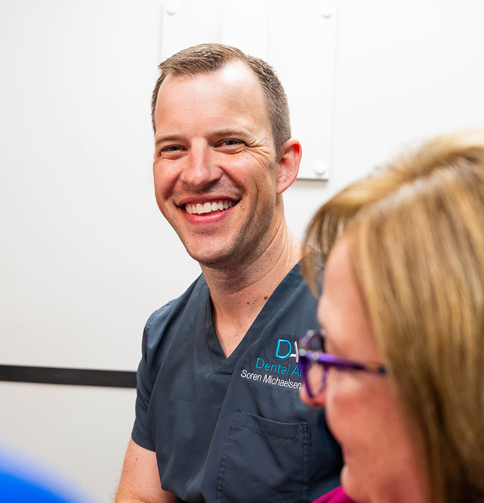 doctor smiling brightly while going over dental procedure information