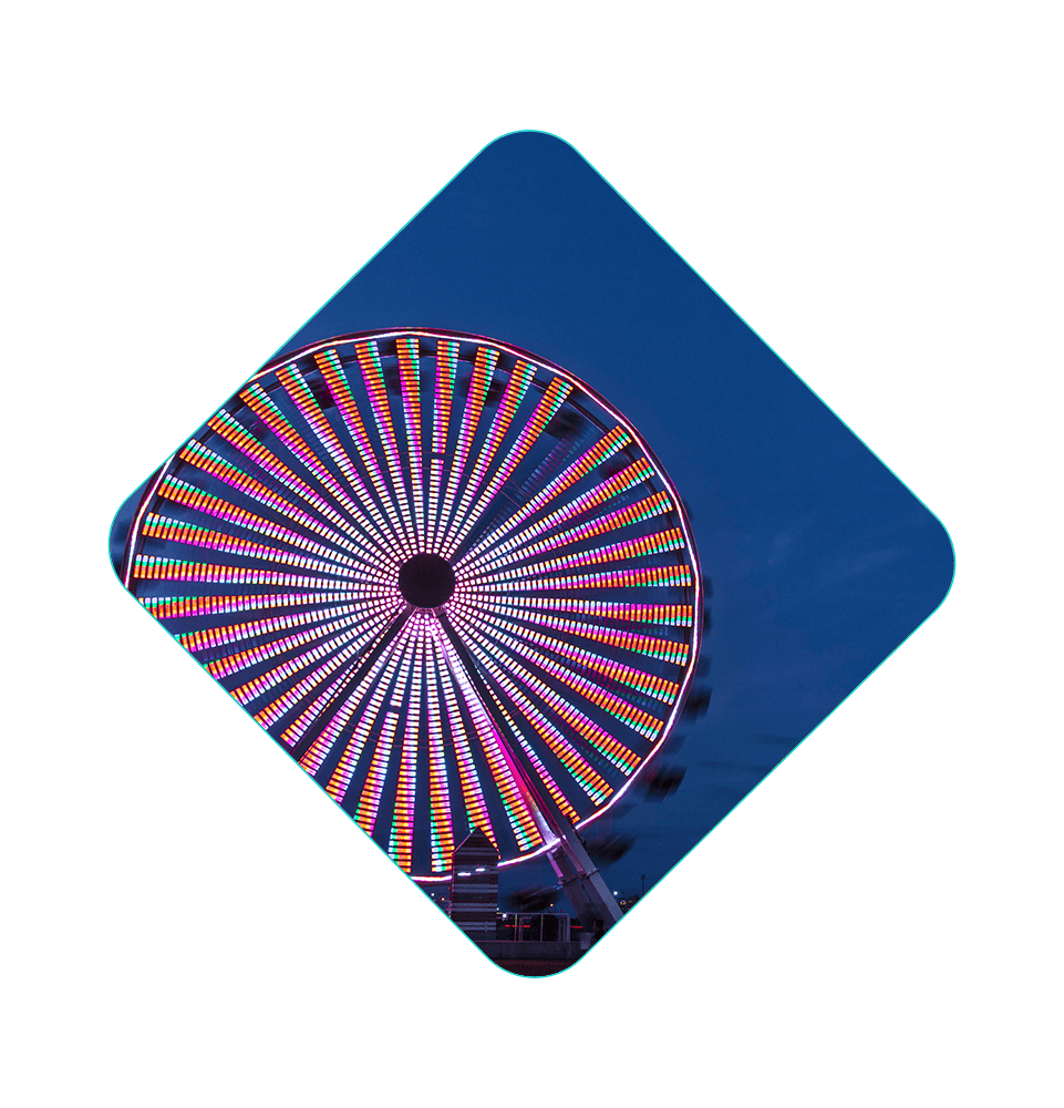 Close up of large neon ferris wheel spinning