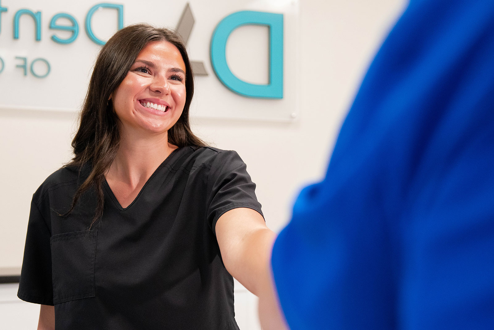 staff member helping patient at the frint desk of the dental center