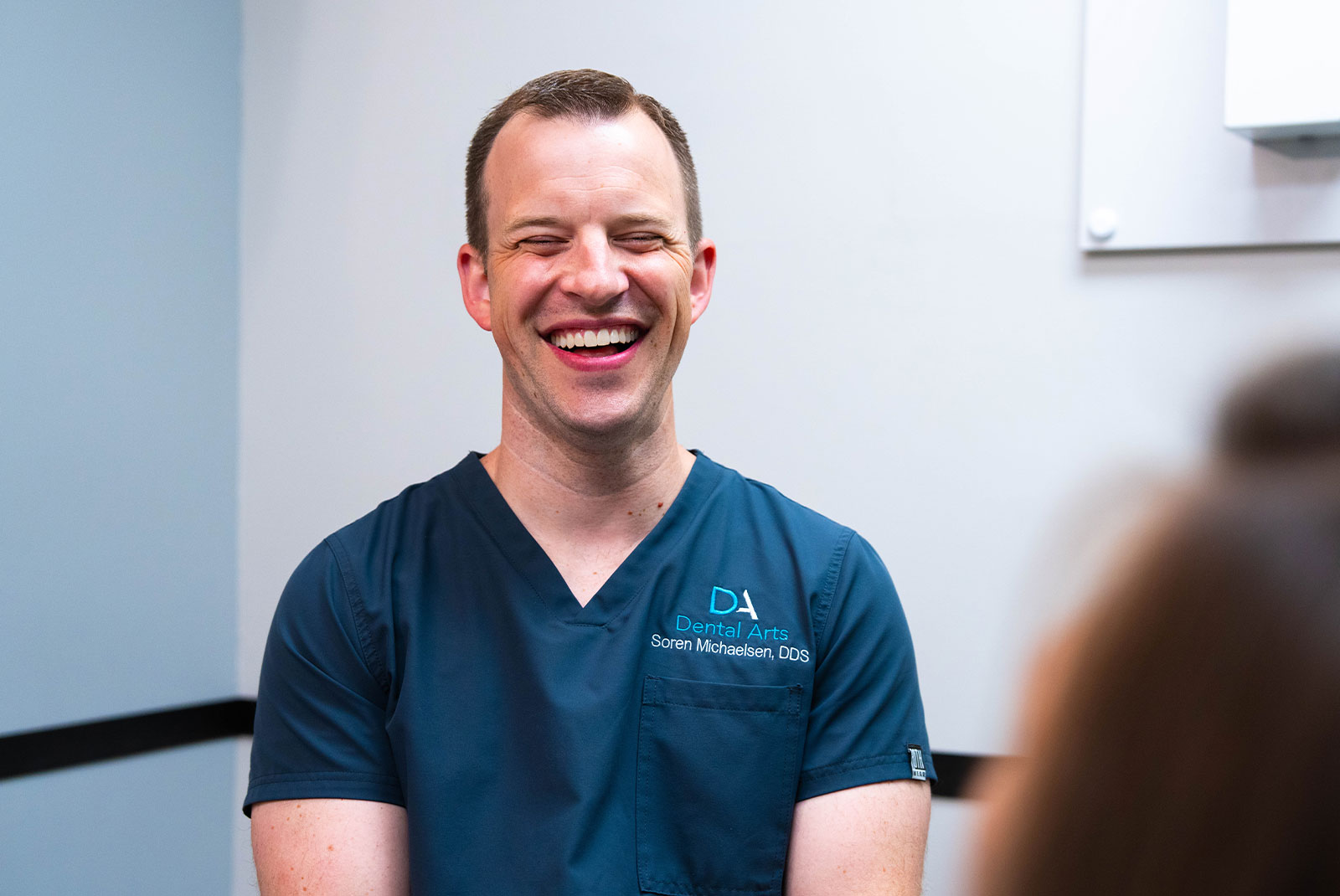 doctor smiling and laughing during dental patient's procedure
