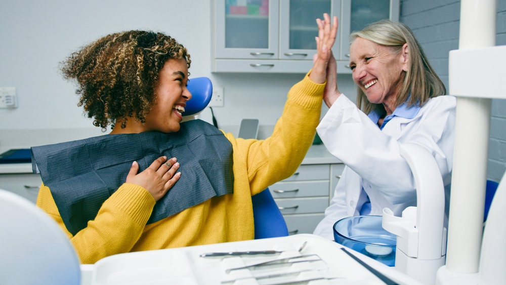 young women smiling talking to a dentist in a dental office